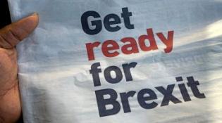 Hand holding newspaper that reads GET READY FOR BREXIT